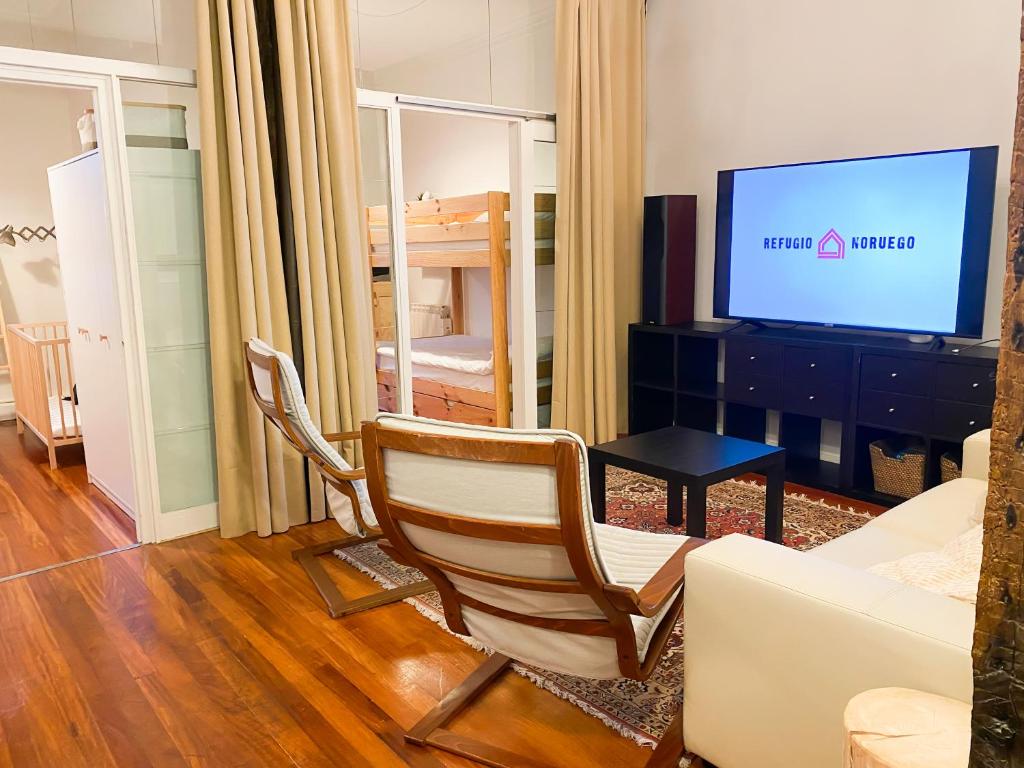 a living room with a chair and a television at Refugio noruego in Bilbao