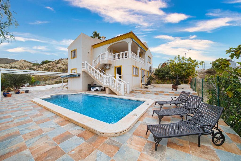 a villa with a swimming pool and a house at El Descanso in El Campello