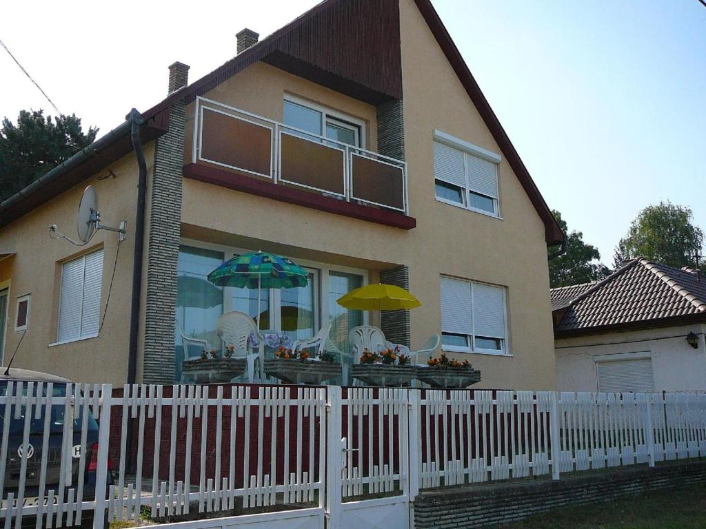 uma casa com uma cerca branca em frente em Großes Ferienhaus in Fonyd mit Großer Terrasse em Fonyód