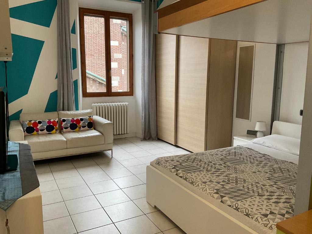 モンツァにあるSawasdee 37のベッドルーム1室(ベッド1台、ソファ、窓付)