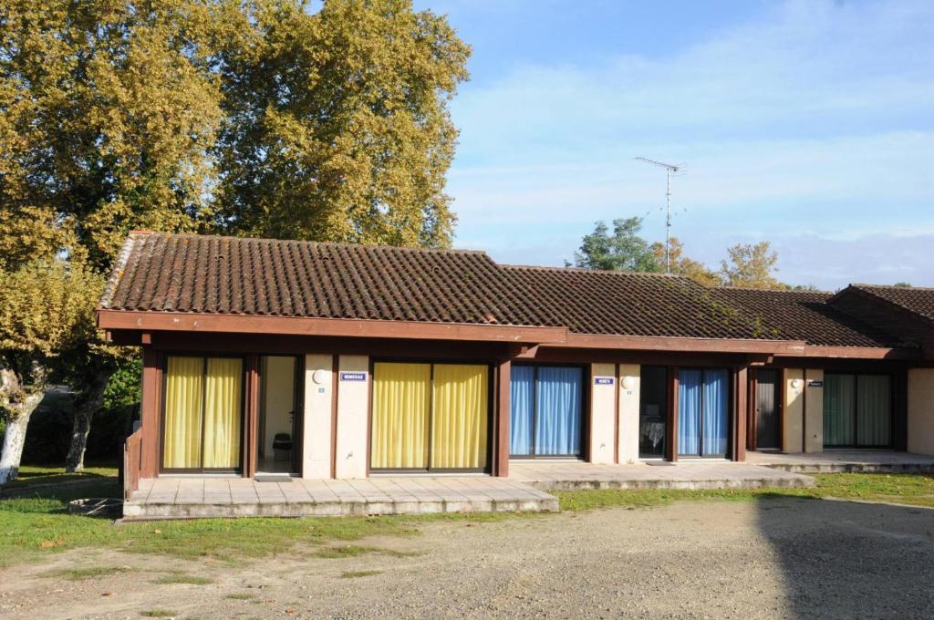 una pequeña casa con puertas amarillas y azules en Arbousiers, en Morcenx