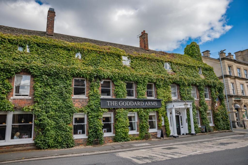 a building covered in ivy on a street at The Goddard Arms in Swindon