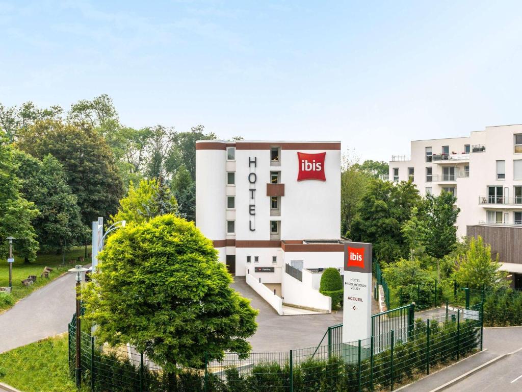 un bâtiment avec un panneau d'affichage devant lui dans l'établissement ibis Paris Meudon Velizy, à Meudon