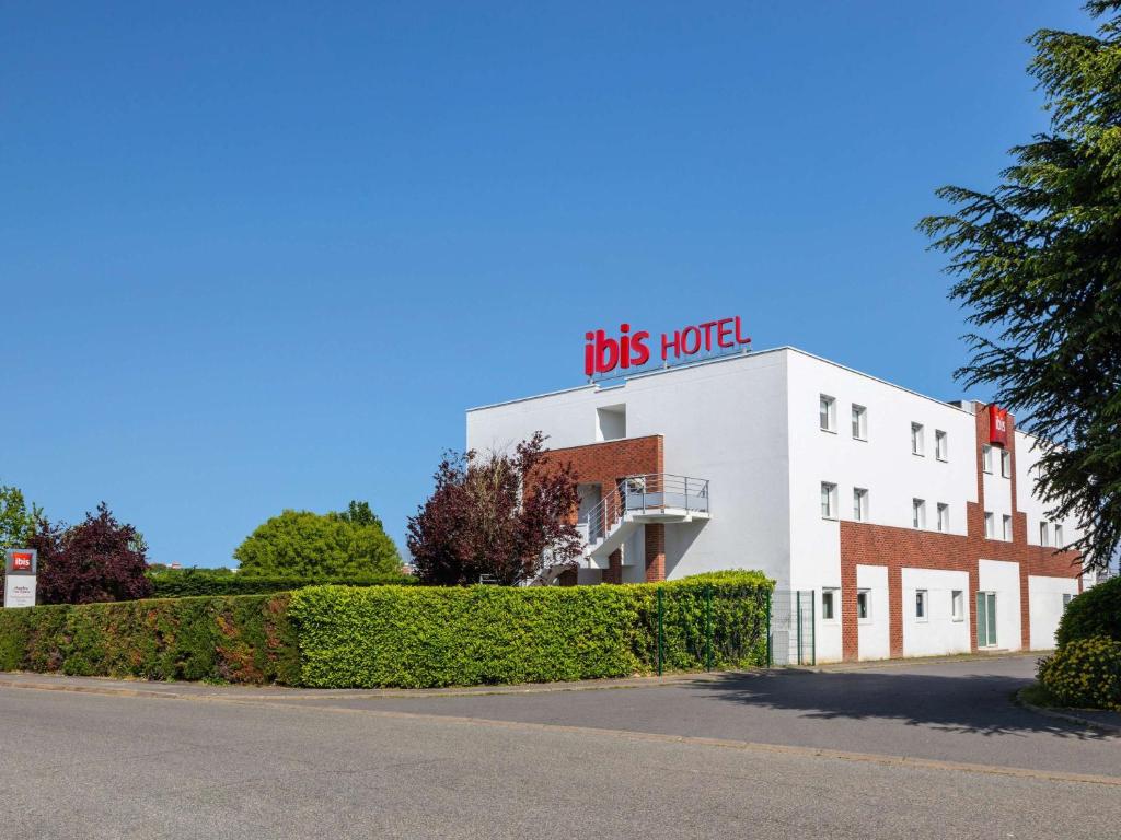 Un bâtiment avec un panneau en haut dans l'établissement ibis Massy, à Massy