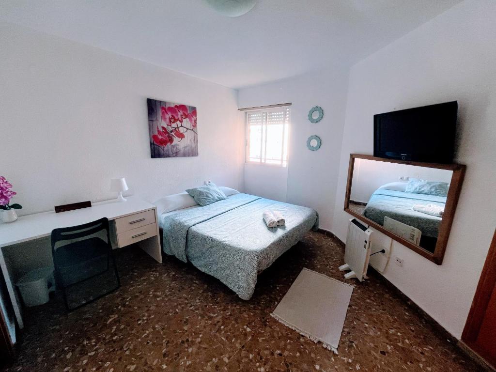 a bedroom with a bed and a desk and a mirror at Confort y relax centro in Valencia