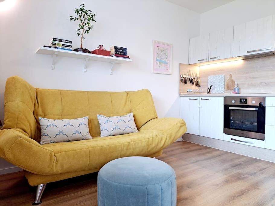 a living room with a yellow couch and a kitchen at Yellow Sofa FREE PARKING Place in Bratislava