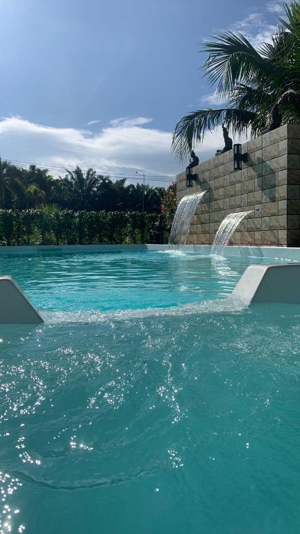 a swimming pool with two water fountains at Pajaree and Udo‘s Happy Homestay in Trang