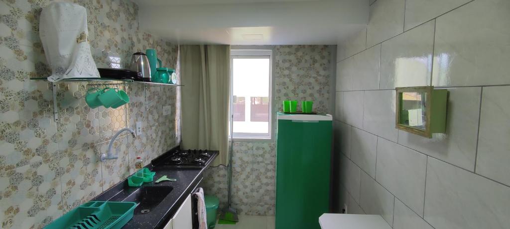 kuchnia z zieloną lodówką i zlewem w obiekcie Guest House Renascer K&W w mieście Cabo Frio