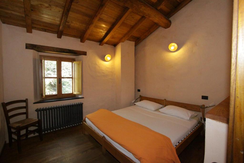 a bedroom with a bed and a chair and a window at Agririfugio Molini in Camogli