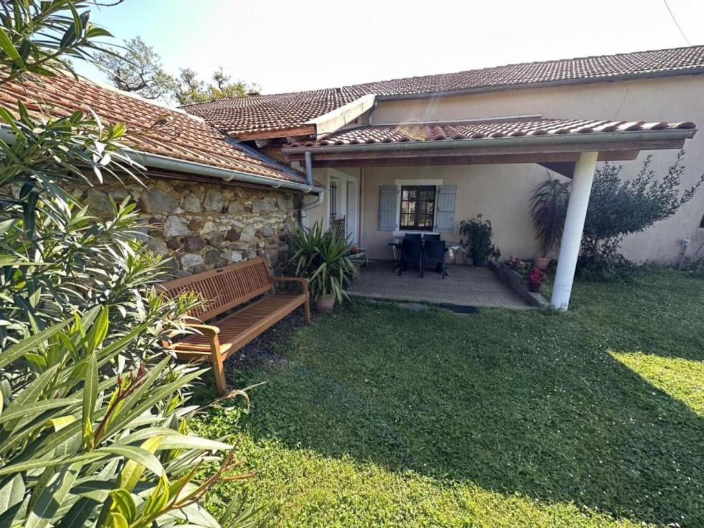 a patio of a house with a bench in the yard at Gîte jean in Horsarrieu