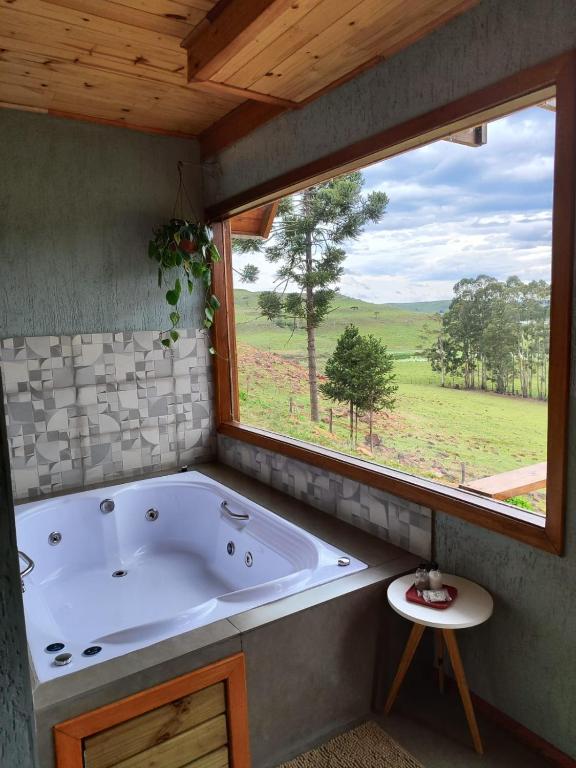 a large bath tub in a room with a window at Cabana Santa Cruz in São Francisco de Paula