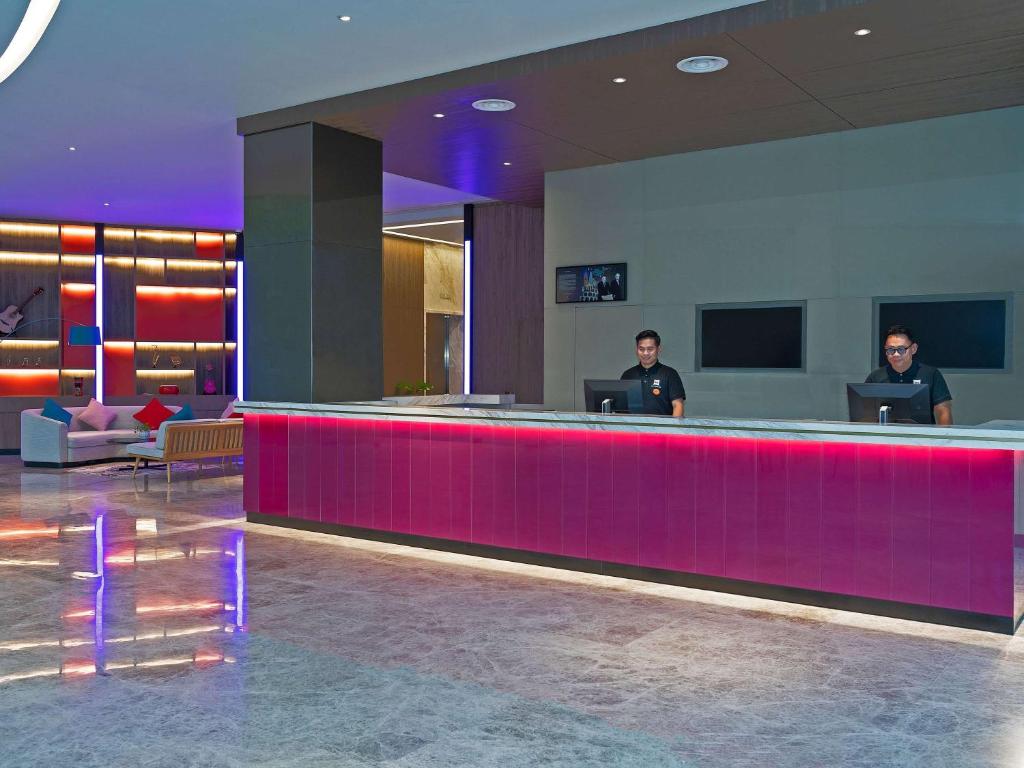 two men standing at a bar in a hotel lobby at ibis PJCC Petaling Jaya in Petaling Jaya