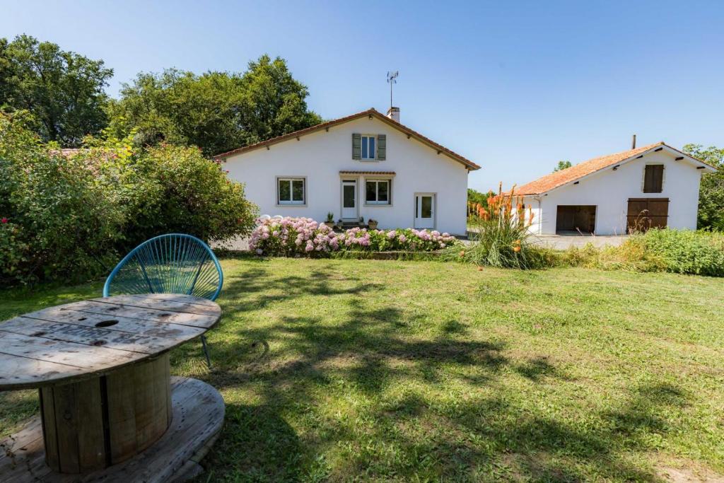 un banco en un patio con una casa en el fondo en Gite caperot, en Eyrès - Moncube