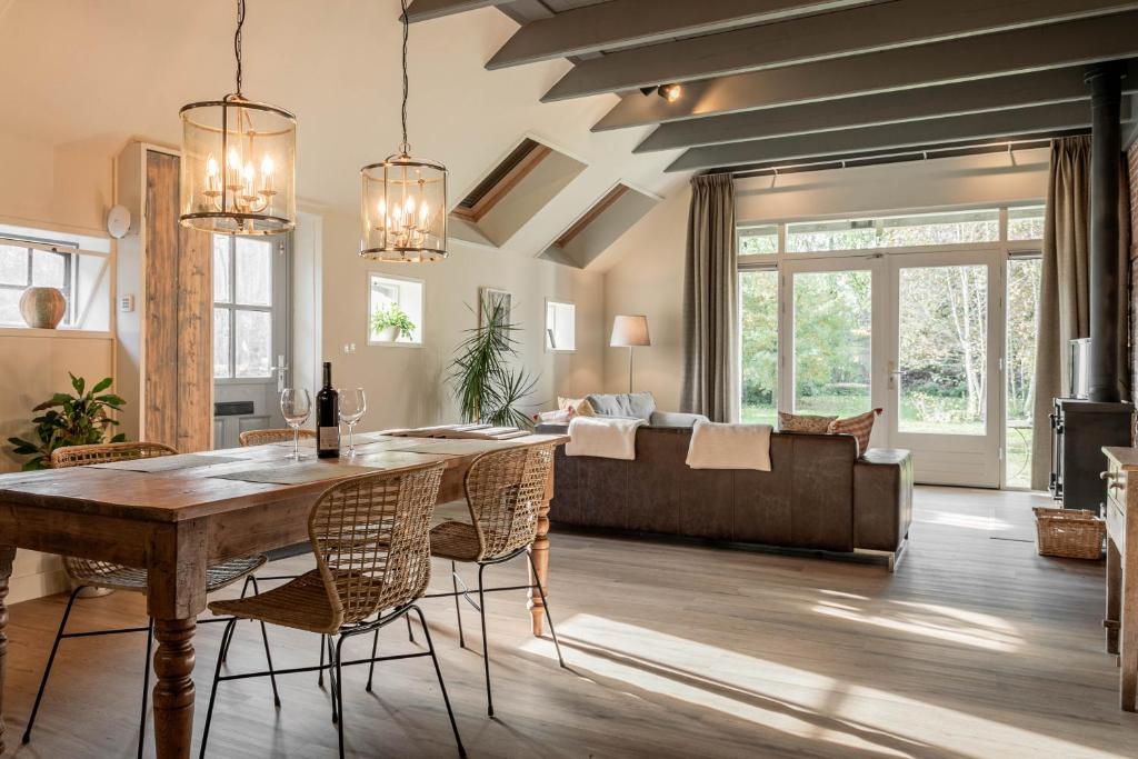 a living room with a table and chairs and a couch at De Lindenhoeve in Valthe