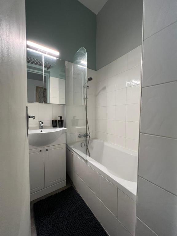 a bathroom with a tub and a sink and a shower at Chic Appartement Climatisé à 10 Minutes de Paris: Confort et Élégance in Maisons-Alfort