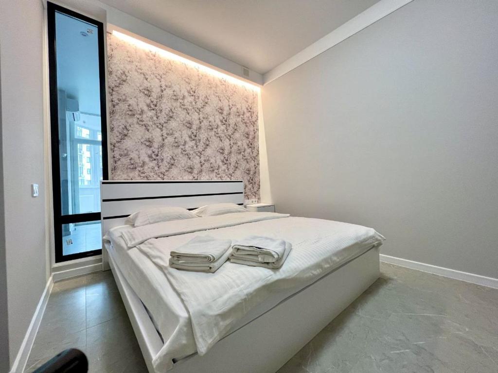 1 dormitorio con 1 cama con 2 toallas en ApartPoltava Стильний дизайн 2023 Двокімнатні апартаменти в ЕЛІТНІЙ НОВОБУДОВІ банківський чек, en Poltava