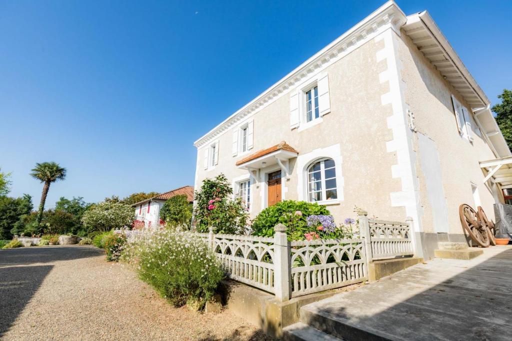 a house with a white fence in front of it at Jouandeou in Donzacq