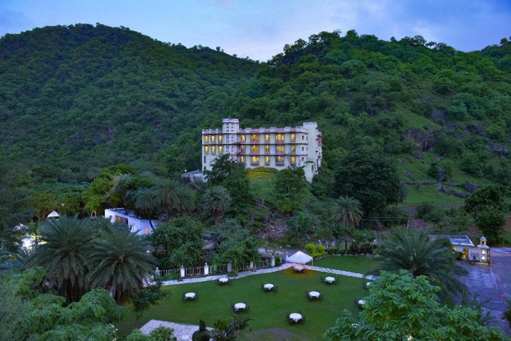a large building in the middle of a field of grass at Aaram Baagh - A Luxury Nature Resort in Udaipur