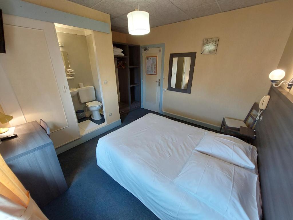 a bedroom with a white bed and a bathroom at Logis Hotels - Le Saint Clément - Hotel Restaurant in Saint-Médard-de-Guizières
