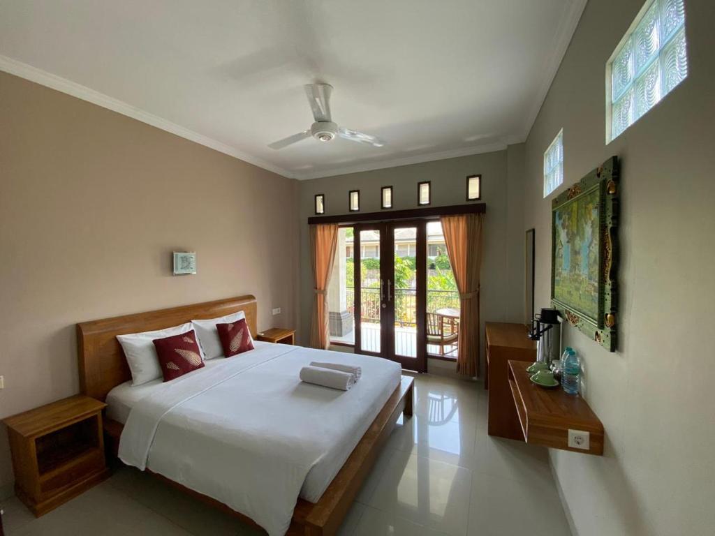 1 dormitorio con cama grande y ventana grande en Umayuri Inn, en Ubud