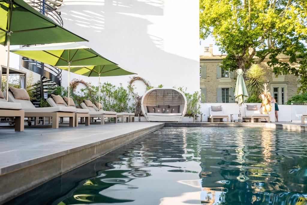 uma piscina exterior com espreguiçadeiras e uma piscina em Le Saint Remy em Saint-Rémy-de-Provence