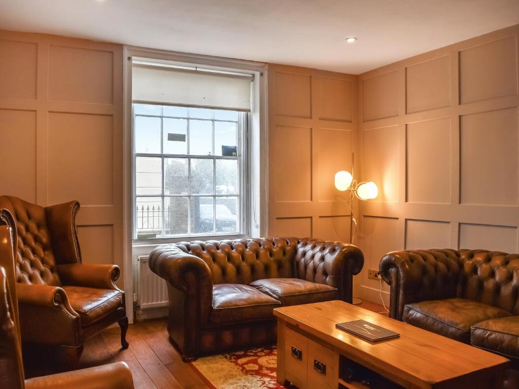 a living room with leather furniture and a window at The Winchester in Deal