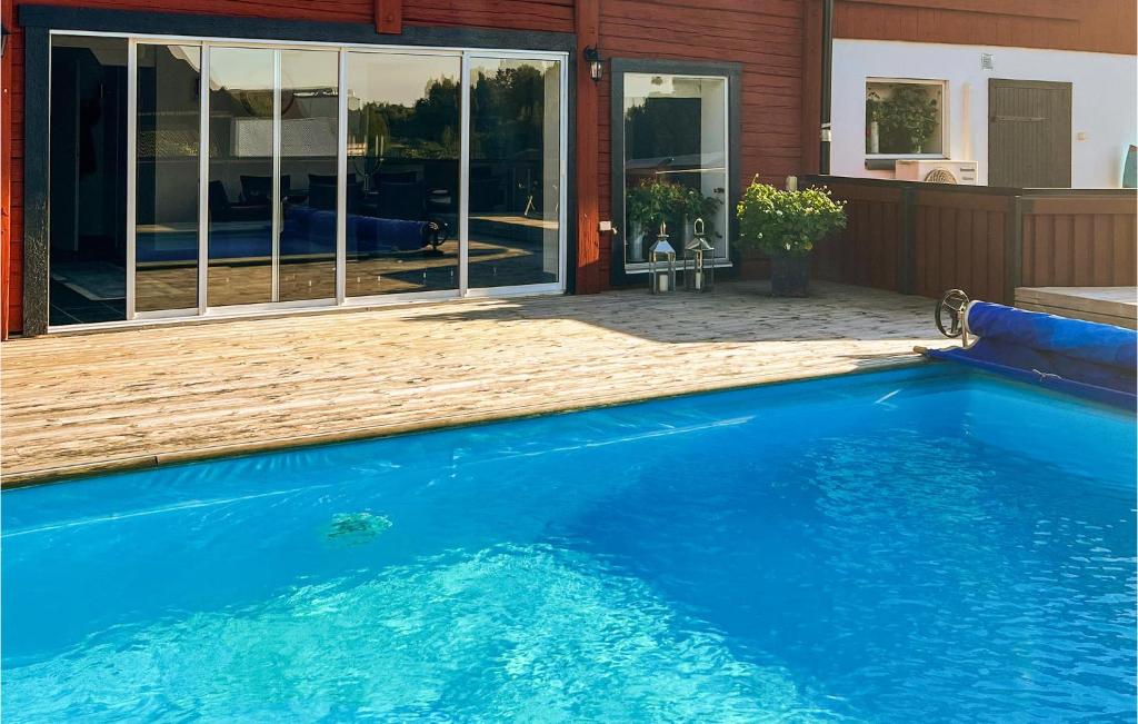 une piscine bleue en face d'une maison dans l'établissement Gorgeous Apartment In Sdra Vi With Kitchen, à Södra Vi