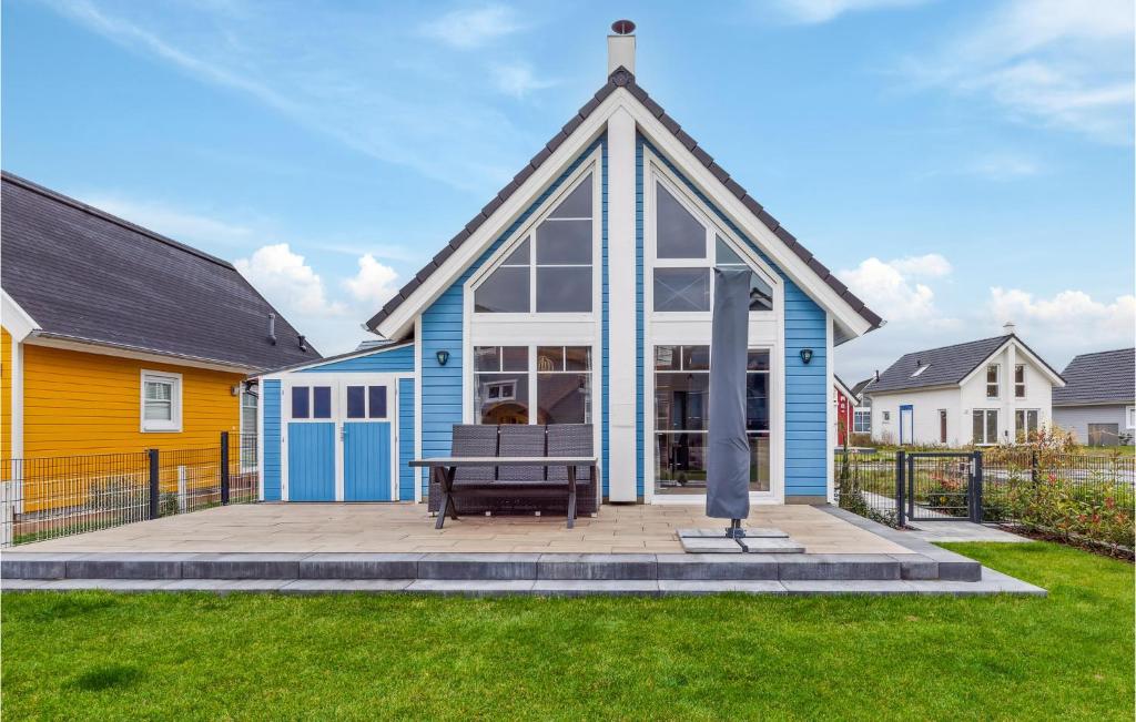 ein blau-weißes Haus mit einer Bank im Hof in der Unterkunft 2 Bedroom Pet Friendly Home In Zerpenschleuse in Zerpenschleuse