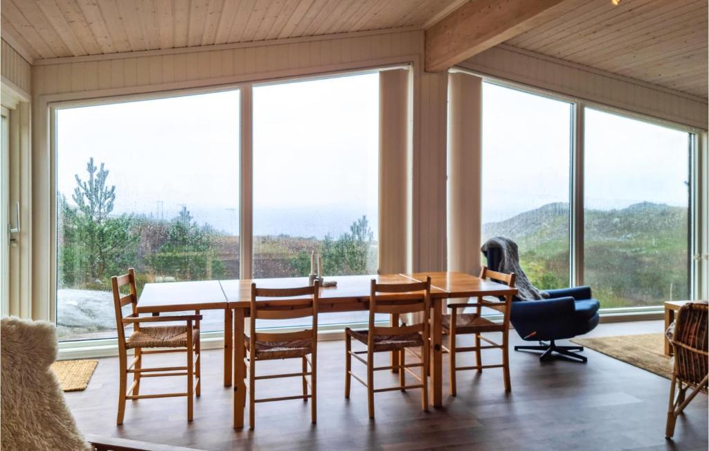 comedor con mesa, sillas y ventanas grandes en Lovely Home In Vanse With House Sea View en Vanse