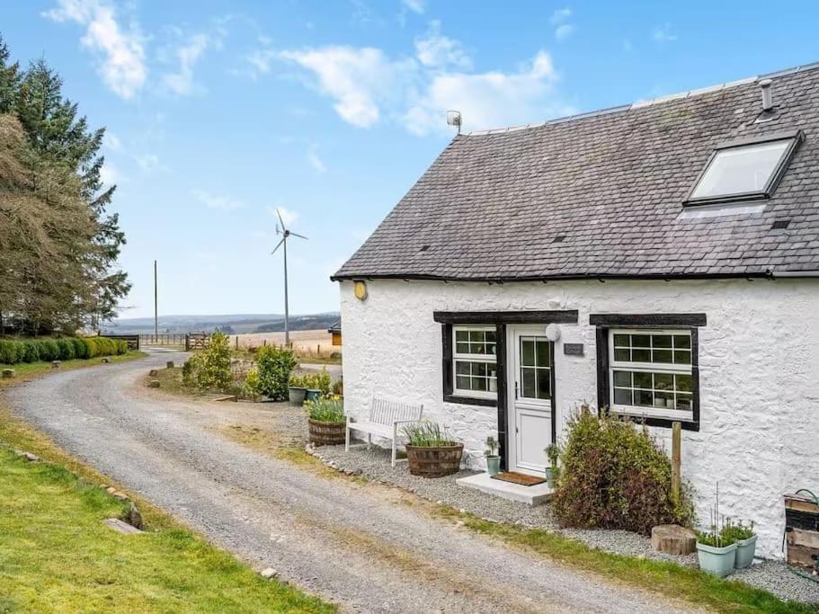 a white cottage with a gravel road at Blackside Cottage in stunning Ayrshire countryside in Mauchline