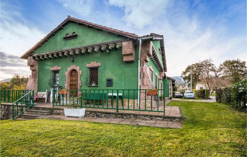 una casa verde con una valla en el patio en Gorgeous Home In Las Regueras With Kitchen, en Santullano