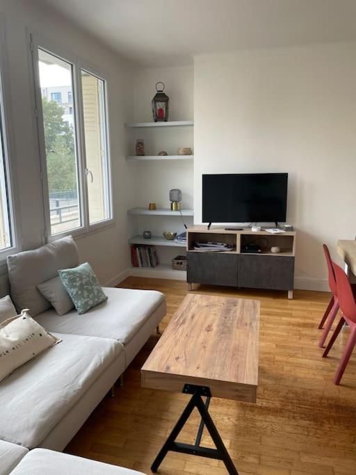 un salon avec un canapé et une télévision à écran plat dans l'établissement Appartement 3 Chambres lumineux Caen hyper CENTRE, à Caen