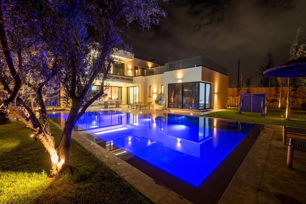 a house with a swimming pool at night at Villa Design à Marrakech in Marrakech