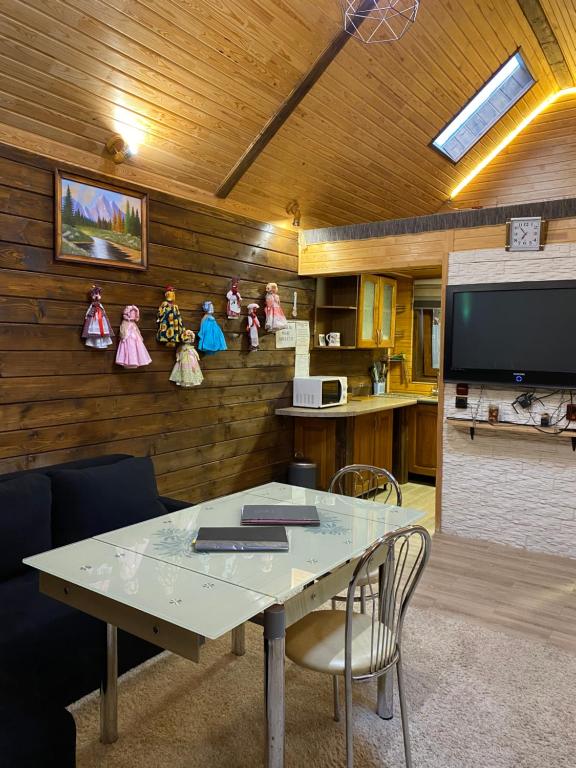 a room with a table and a tv and some figurines at Guest house Shulc in Mizhhirya
