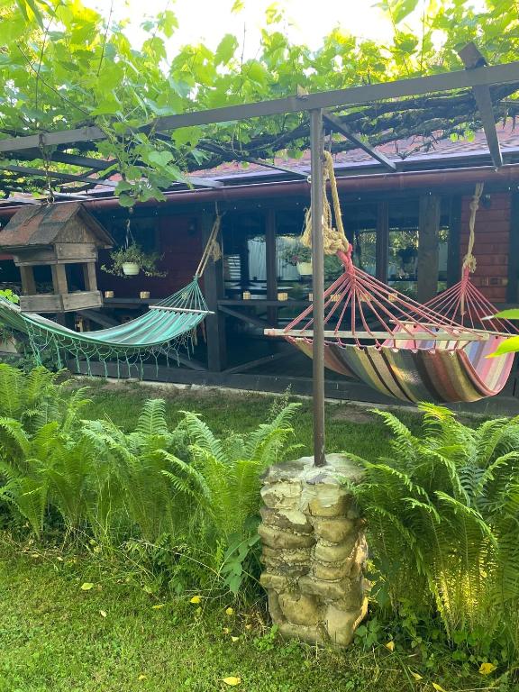 a couple of hammocks in front of a house at Guest house Shulc in Mizhhirya