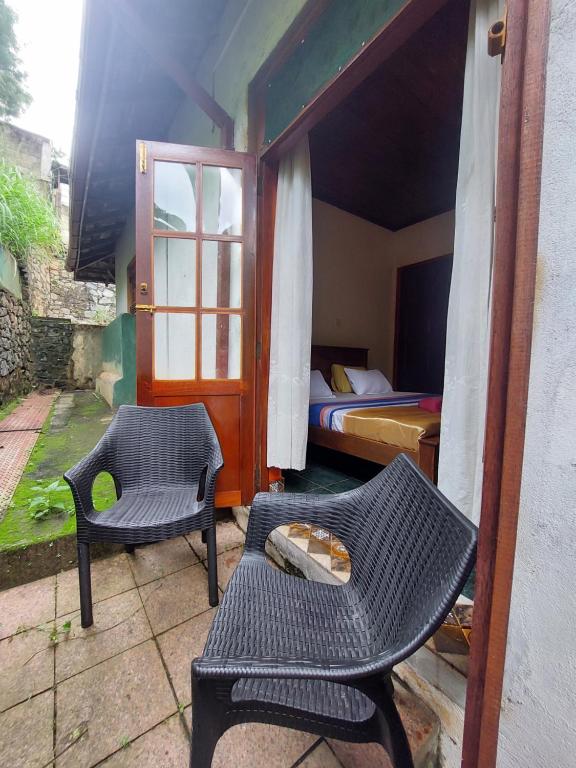a room with a bed and a table and chairs at Mystique Hideout in Kandy
