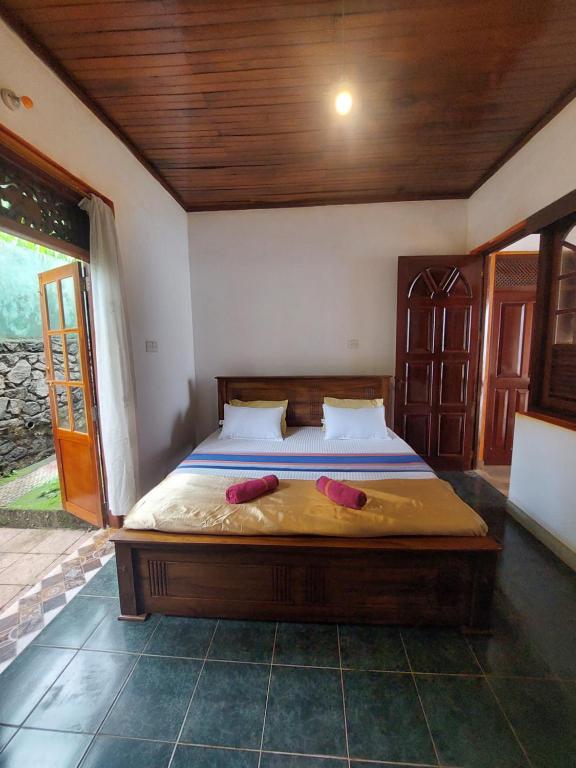 a bedroom with a bed with two red shoes on it at Mystique Hideout in Kandy