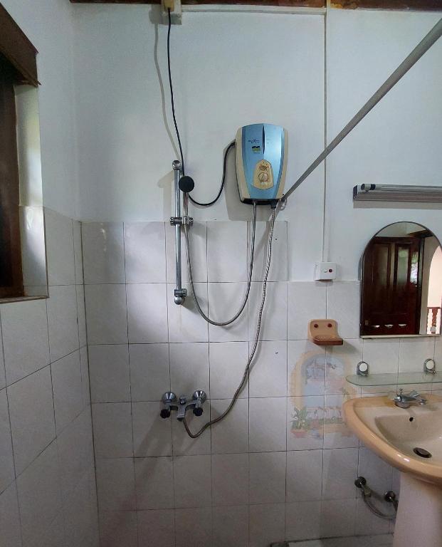 a bathroom with a shower with a blue box on the wall at Mystique Hideout in Kandy