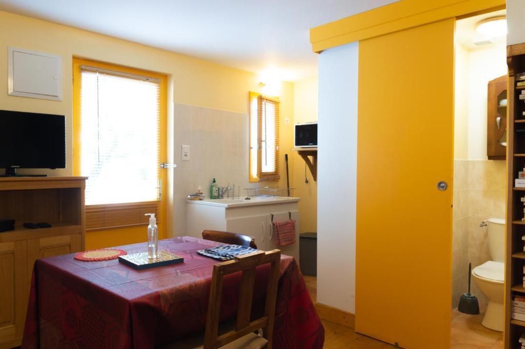una camera con tavolo e una cucina con tavolo e tavolo di Studio calme et chaleureux a Brive-la-Gaillarde