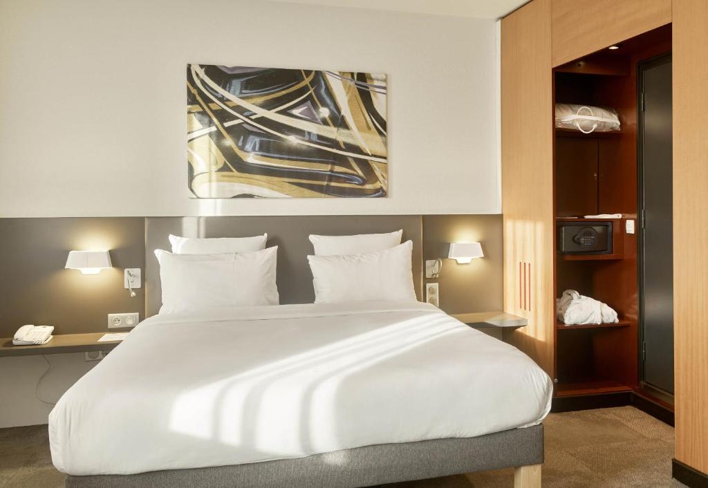 1 cama blanca grande en una habitación de hotel en B&B HOTEL Paris Nord 18ème en París