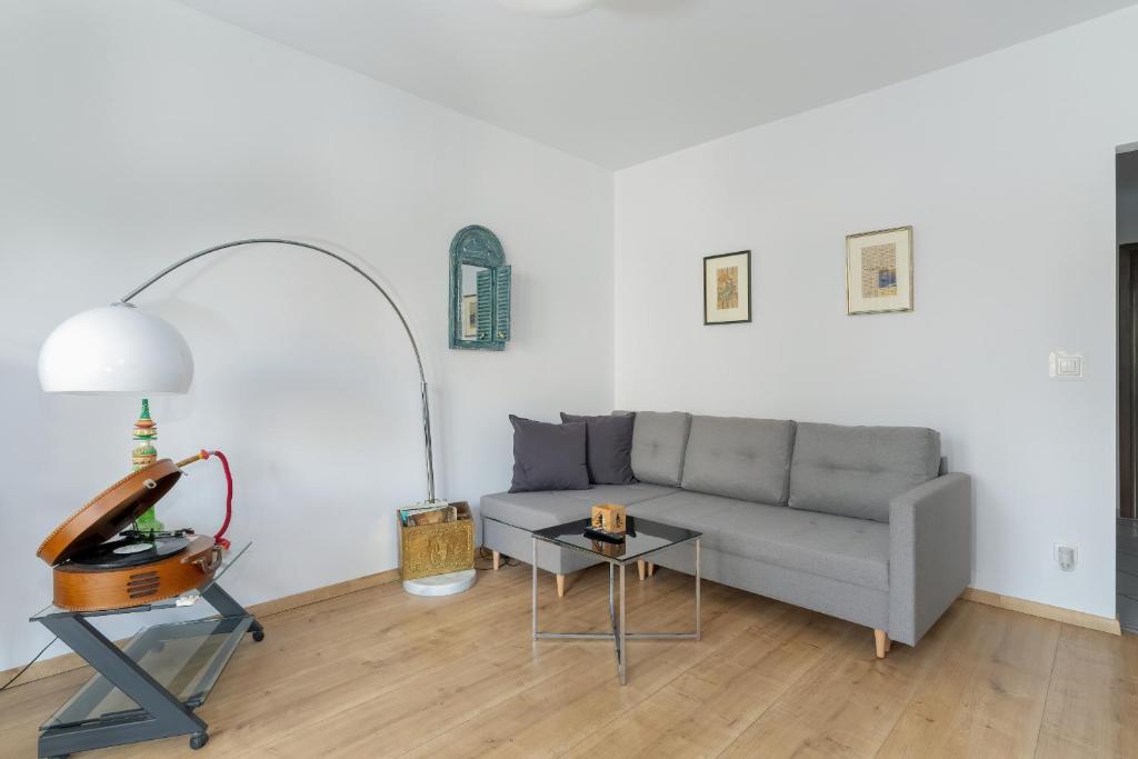 a living room with a couch and a table at Stylish Studio for 2 with Balcony Robocza Poznań by Renters in Poznań