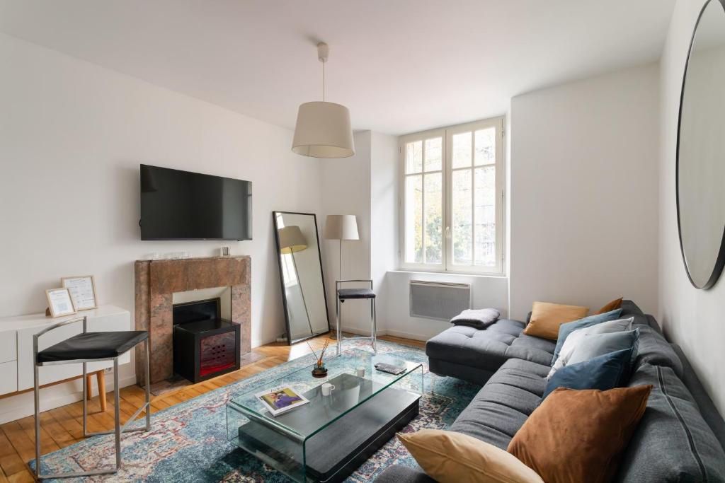 un salon avec un canapé et une cheminée dans l'établissement L'ECRIVAIN by Cocoonr, à Rennes