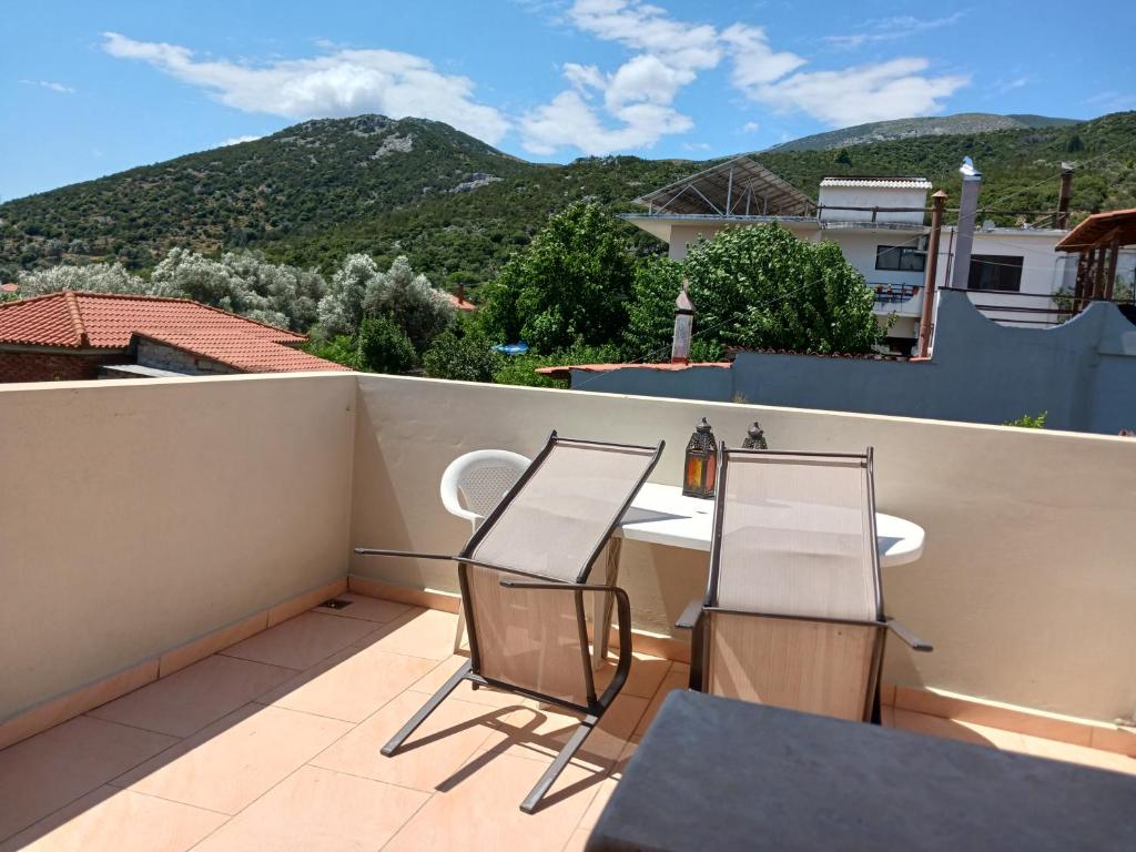 a balcony with two chairs and a table on a roof at Vagia's Home in Kymi