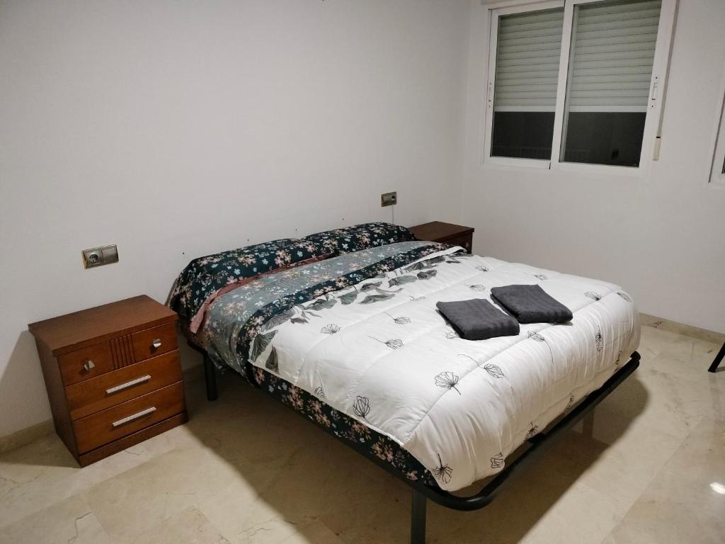 a bedroom with a bed and a wooden night stand at Piccadilly Centre Deluxe in Alicante