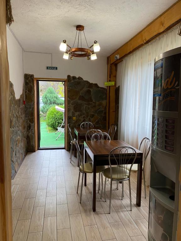 uma sala de jantar com uma mesa e cadeiras e uma janela em Guest house Shulc em Mizhhirya