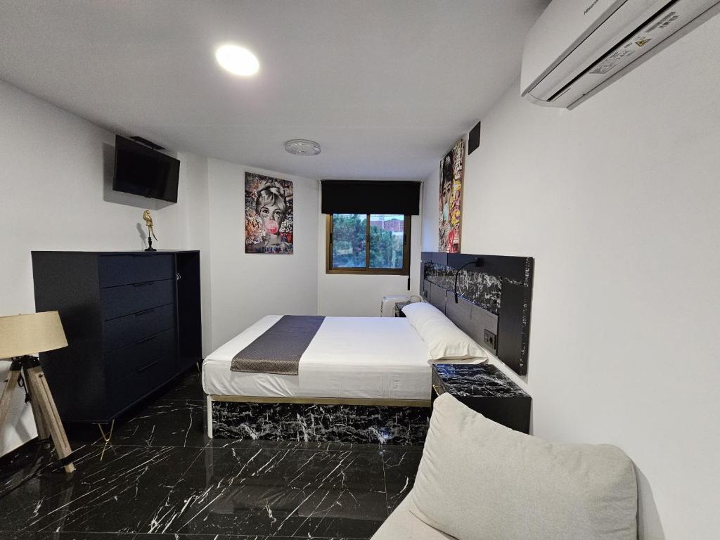 mała sypialnia z łóżkiem i kanapą w obiekcie Apartamentos Benidorm Black w mieście Benidorm
