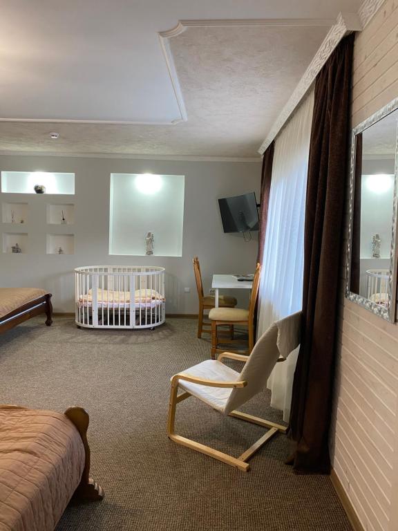 a bedroom with a crib and a room with a bed and a crib at Guest house Shulc in Mizhhirya
