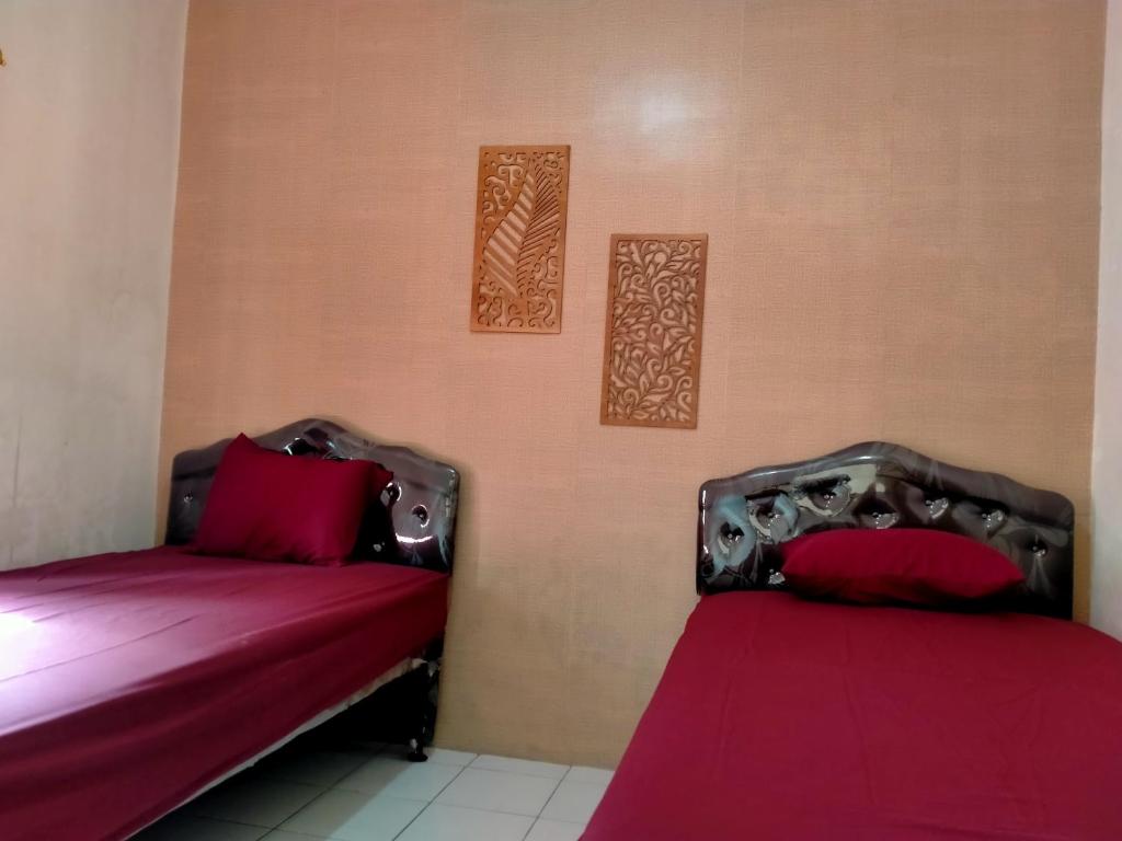 duas camas sentadas uma ao lado da outra num quarto em GH SIRNAMISKIN em Bandung