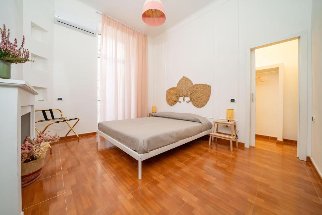 um quarto com uma cama e piso em madeira em Casa Blin Dimora a Chiaia em Nápoles