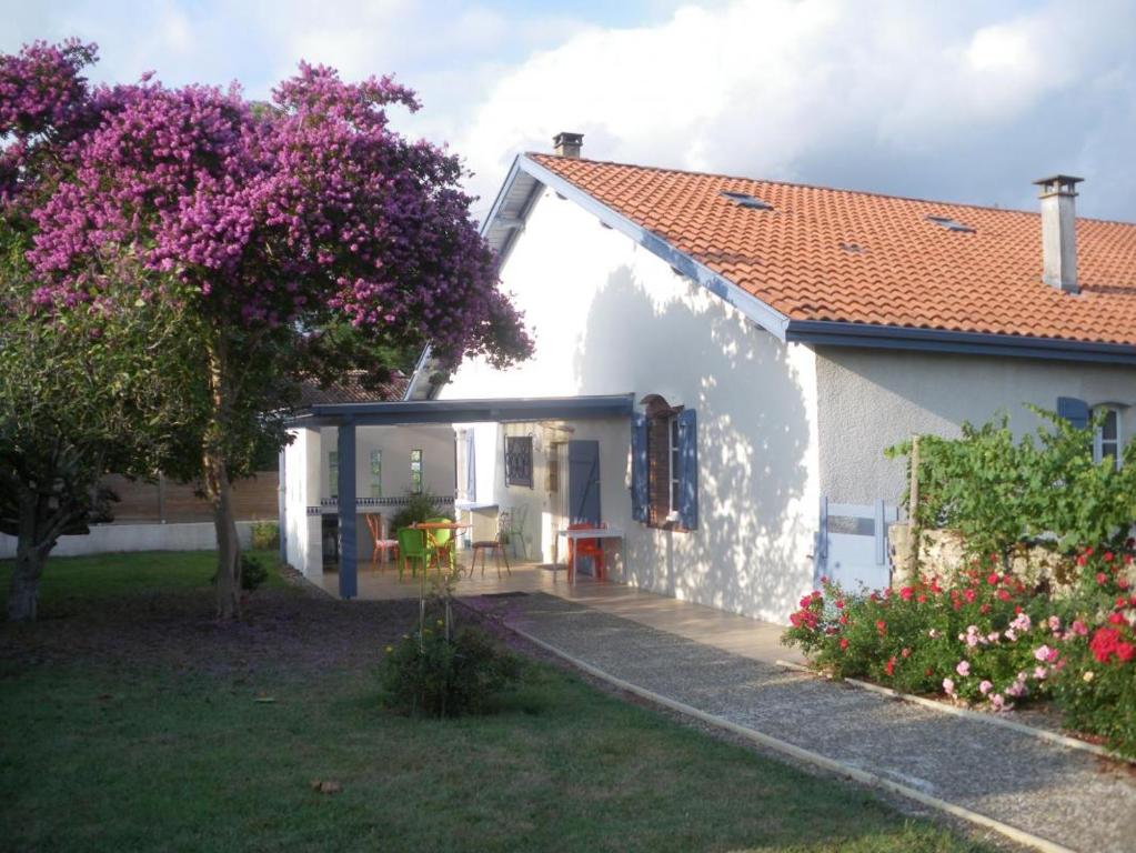 una casa bianca con un giardino e un albero di Le zihans a Port-de-Lannes